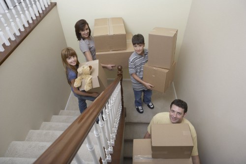 Professional movers carrying household furniture through a Hampstead home